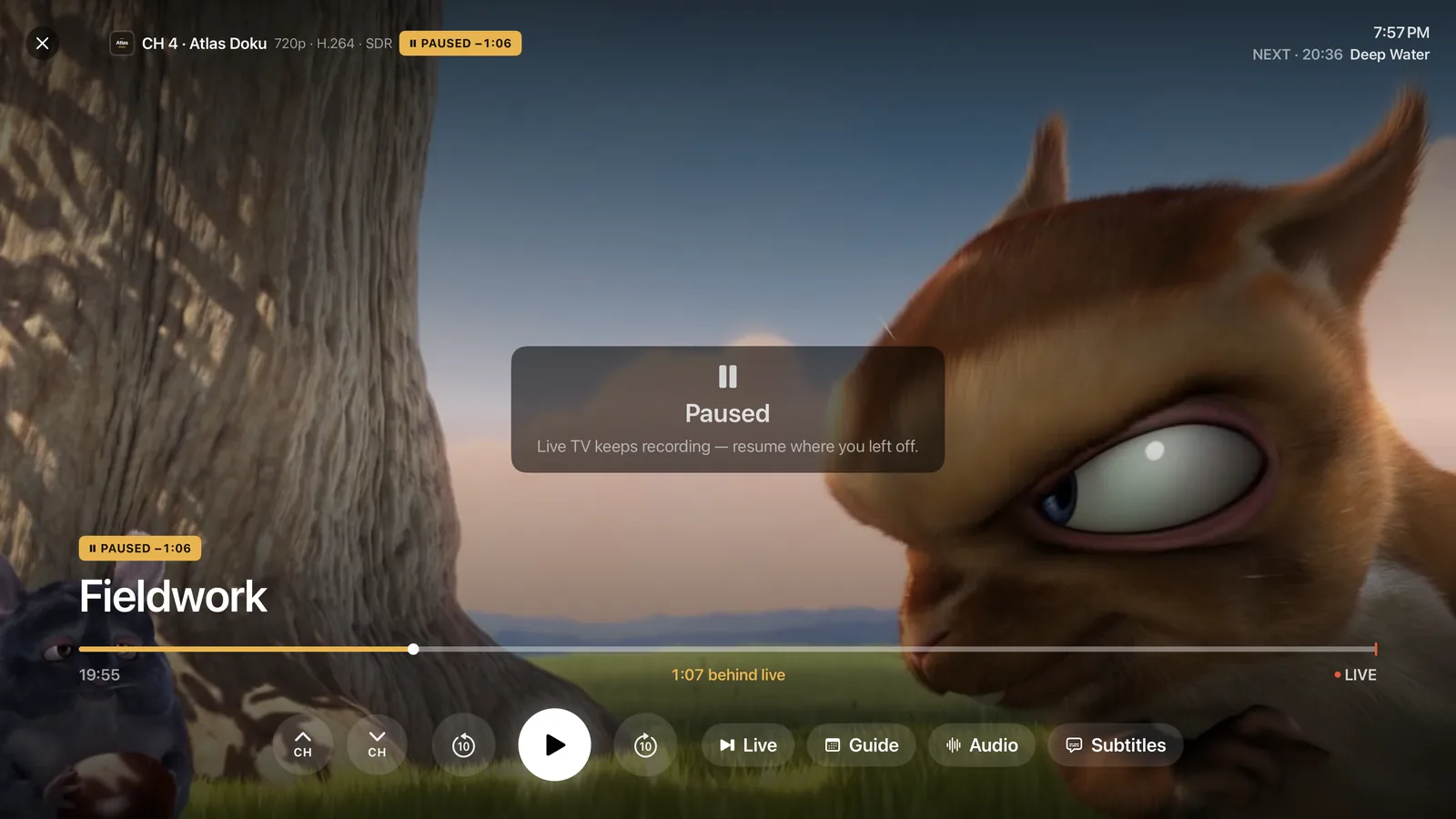 A live channel paused on Apple TV, a minute behind live, with Live, Guide, Audio and Subtitles buttons